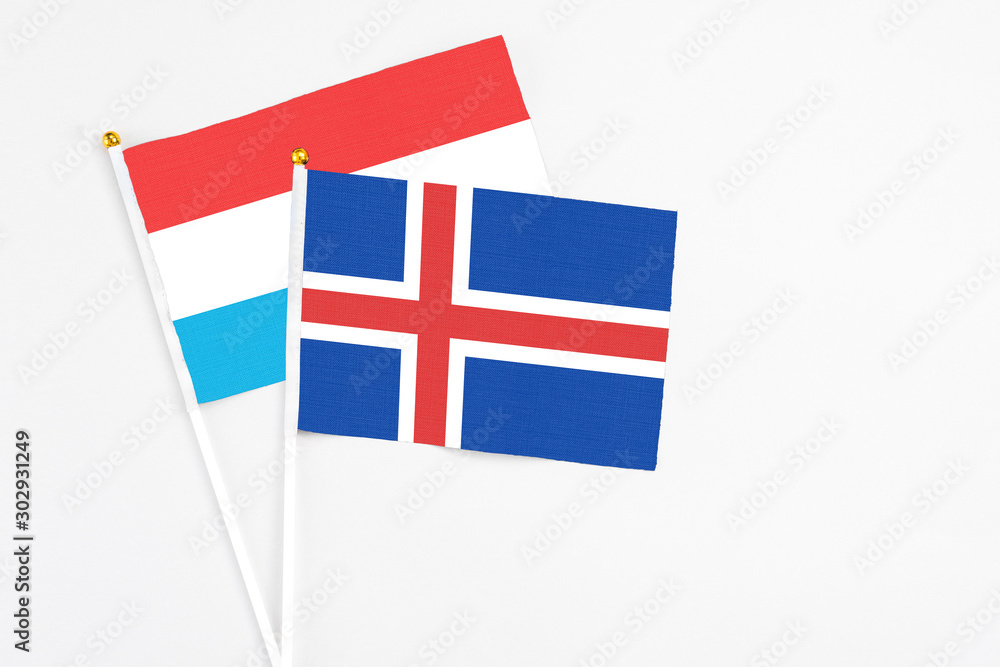 Iceland and Luxembourg stick flags on white background. High quality fabric, miniature national flag. Peaceful global concept.White floor for copy space.