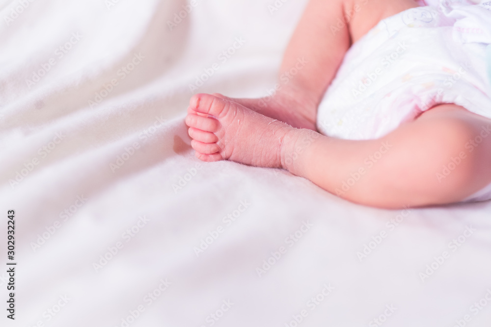 Close-up of newborn baby girl's tiny legs and feet, selective focus photograph. Close-up of newborn baby girl's tiny legs and feet, selective focus photograph.