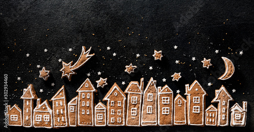 Photography Christmas background, gingerbread  cookies houses and gingerbread stars  on a black  background