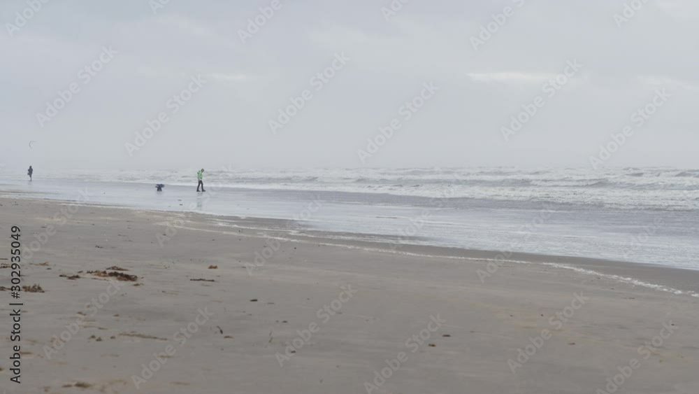 People and children walking across the the North Sea beach. Slow Motion People and children walking across the the North Sea beach. Slow Motion