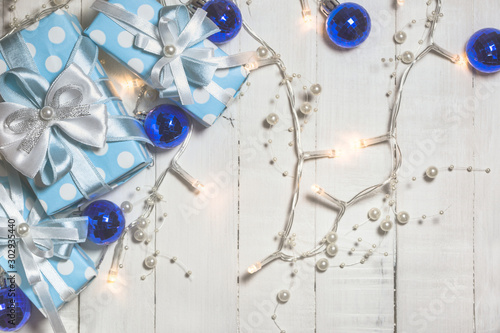 Blue gift boxes and ornaments on white wooden background