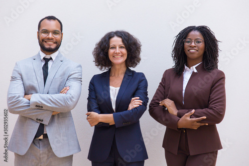 Happy confident business team posing with arms folded. Business man and women standing isolated over white background. Corporate group portrait concept photo