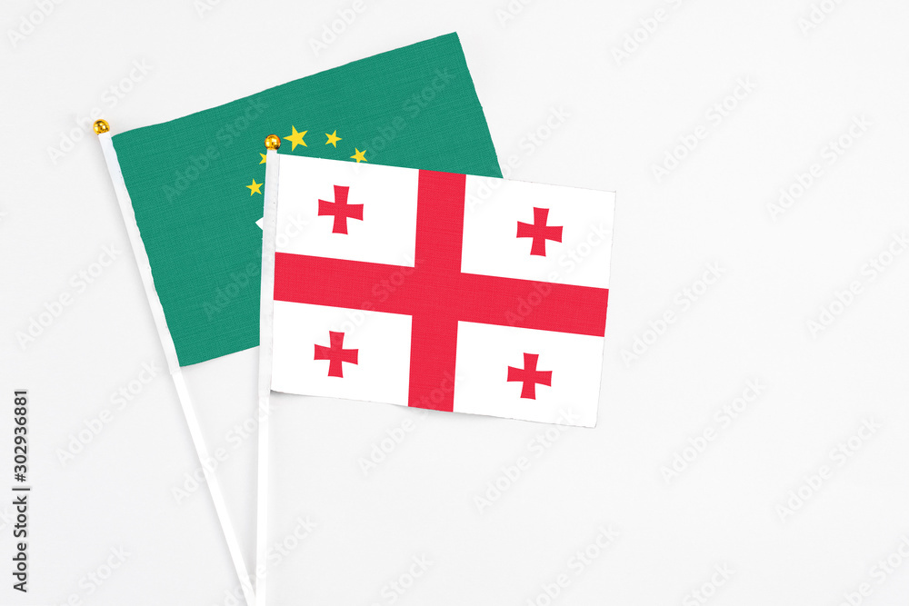 Georgia and Macao stick flags on white background. High quality fabric, miniature national flag. Peaceful global concept.White floor for copy space.
