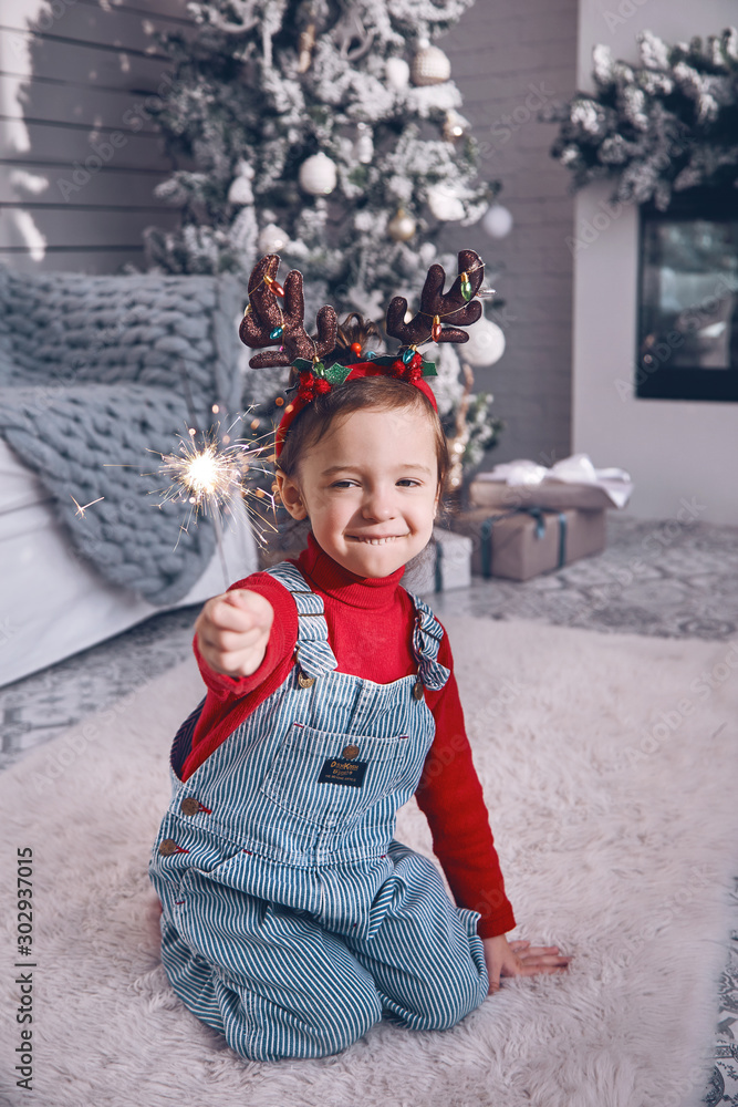 A small child holds a burning sparkler in his hand. Christmas celebration. A small child holds a burning sparkler in his hand. Christmas celebration.