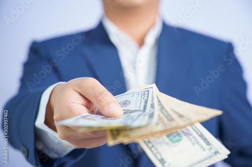 Business man and money in us dollar hold on hand wearing a blue suit and Give to me USD, Pay, exchange money vietnamese on white background. photo