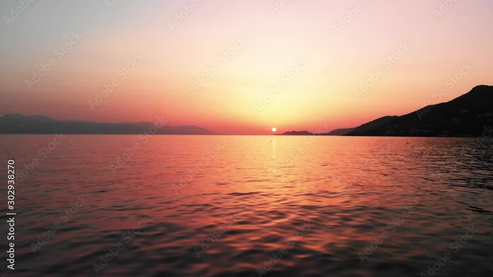 Drone flying over the sea at Loutraki, Greece. Aerial footage, stock video. Drone flying over sea towards the sunset / sunrise