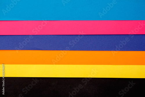 Colorful paper on black background. The view from the top. Space for text