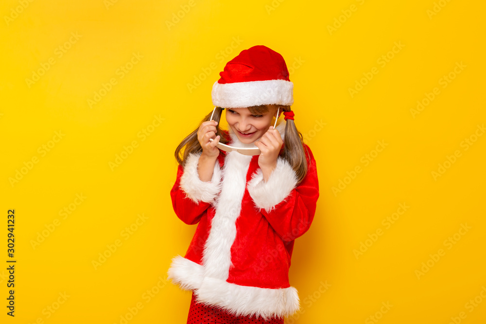 Child in Santa costume putting on party glasses Child in Santa costume putting on party glasses