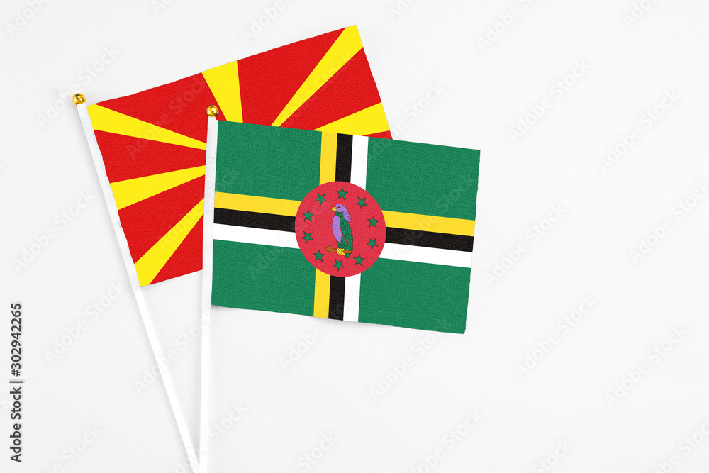 Dominica and Macedonia stick flags on white background. High quality fabric, miniature national flag. Peaceful global concept.White floor for copy space.