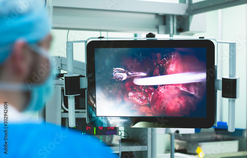 Medical robot, surgeon. Operating room modern technology, operation with a robot. Robotic surgery. The doctor performing the operation on a person, human organs are displayed on the monitor screen