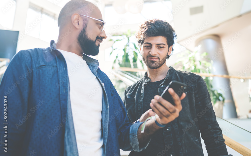 Stylish chatting men sharing mobile phone Stylish chatting men sharing mobile phone