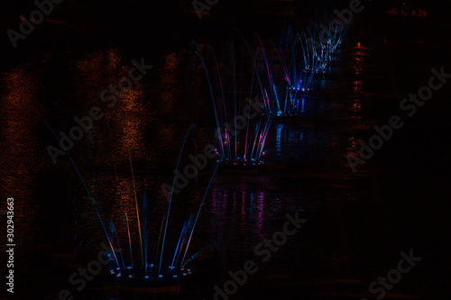 Ukraine. Kyiv - 05.06.2019 Amazing dancing fountain in the night illumination of rainbow color with colorful illuminations on the lake. © Yuliia