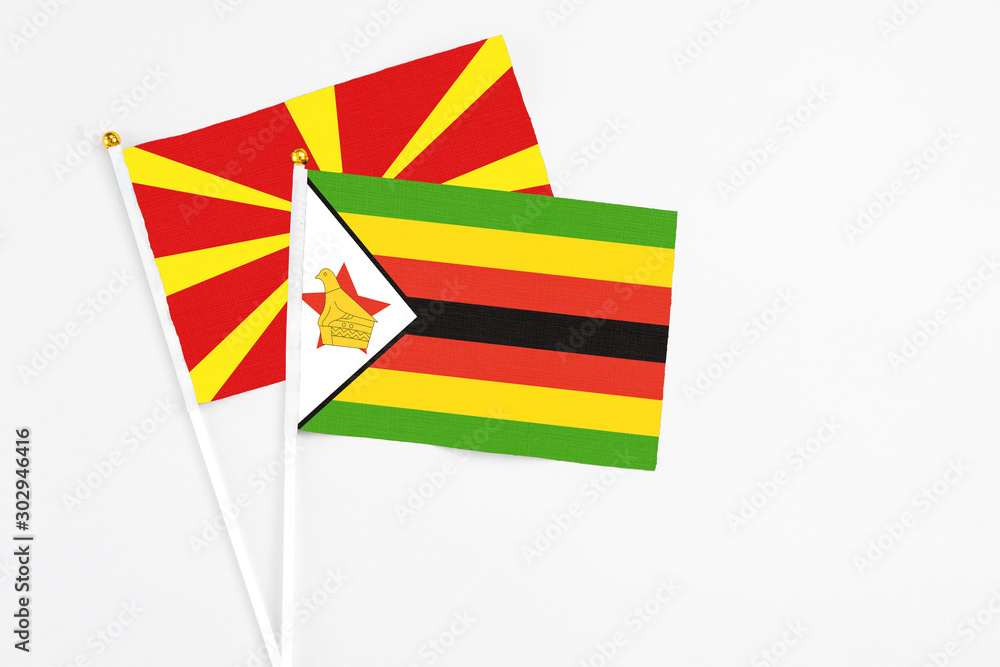 Zimbabwe and Macedonia stick flags on white background. High quality fabric, miniature national flag. Peaceful global concept.White floor for copy space.,