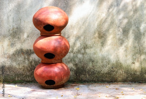 Three brown clay pots arranged one by one in a straight manner