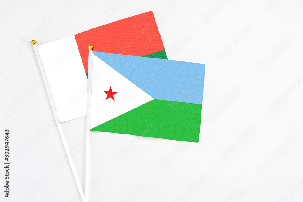 Djibouti and Madagascar stick flags on white background. High quality fabric, miniature national flag. Peaceful global concept.White floor for copy space. Djibouti and Madagascar stick flags on white background. High quality fabric, miniature national flag. Peaceful global concept.White floor for copy space.