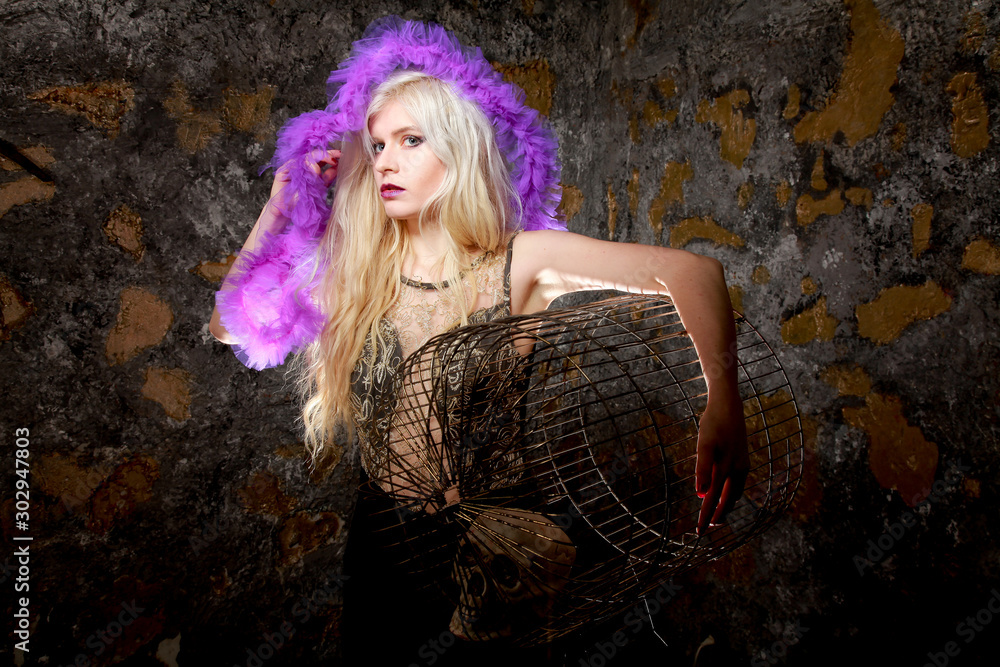 dark goth girl with big bird cage in arms on dark background standing alone dark goth girl with big bird cage in arms on dark background standing alone