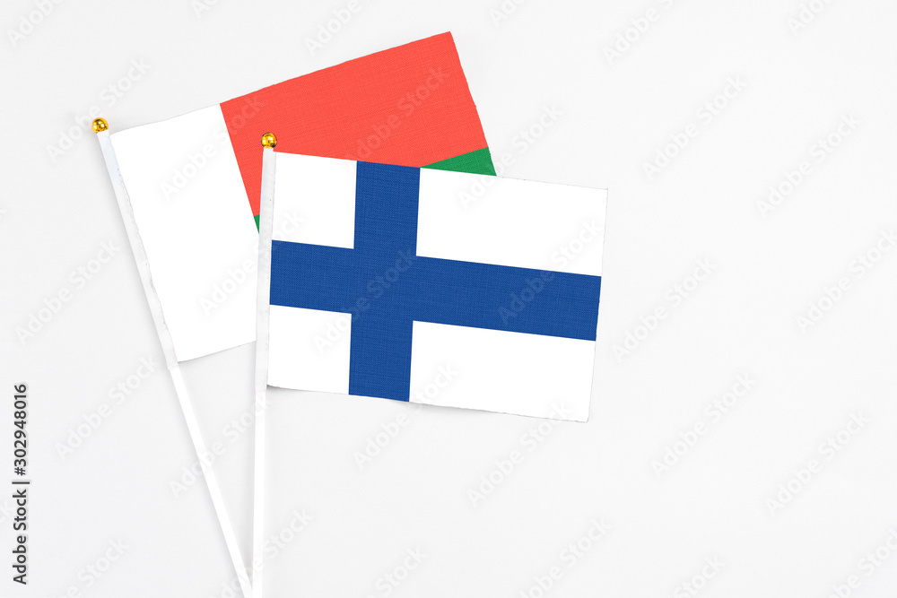 Finland and Madagascar stick flags on white background. High quality fabric, miniature national flag. Peaceful global concept.White floor for copy space.