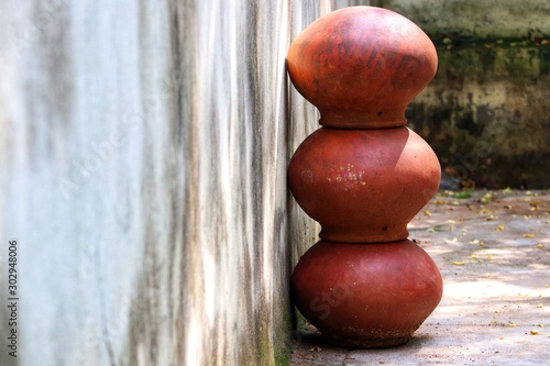 Three brown clay pots arranged one by one in a straight manner