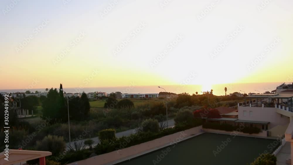 Panoramic top view of the golden hour light of the ocean horizon with lens flare from the resort balcony in Paphos Cyprus