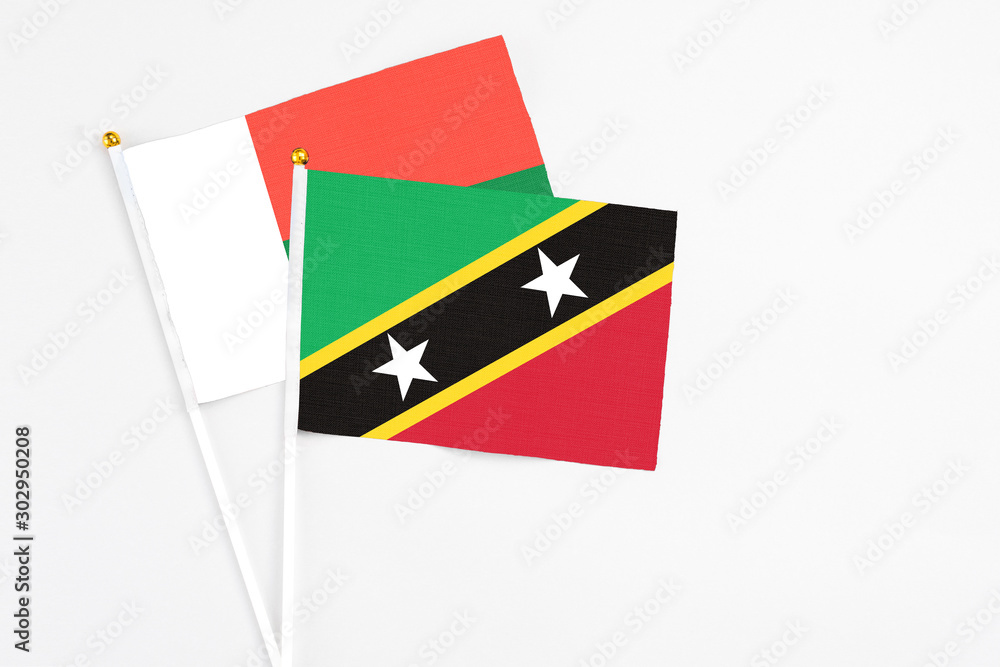 Saint Kitts And Nevis and Madagascar stick flags on white background. High quality fabric, miniature national flag. Peaceful global concept.White floor for copy space. Saint Kitts And Nevis and Madagascar stick flags on white background. High quality fabric, miniature national flag. Peaceful global concept.White floor for copy space.