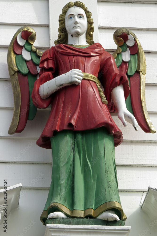 Old wooden and painted angel statue at a white house at the hanseatic wharf at Bryggen in Bergen, Norway, Europe