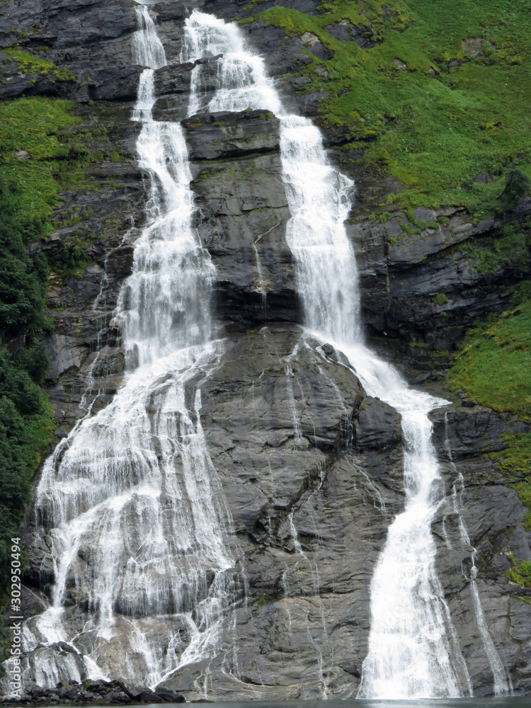 Fototapeta premium The Suitor waterfall is shaped like a bottle and is located opposite the Seven Sisters waterfalls on the Geirangerfjord. You pass by if you take a ferry from Geiranger to Hellesylt; Norway, Europe