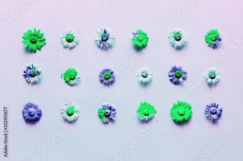 Neon light bright background with flower heads of daisies with flowing liquid paint.