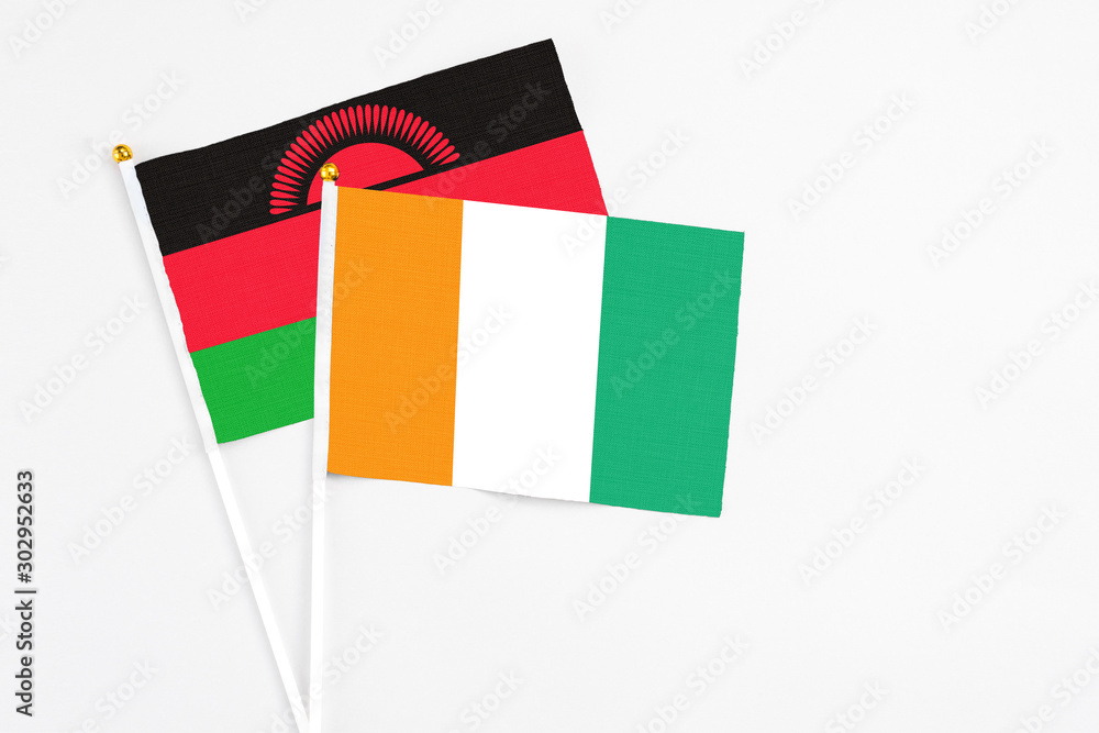 Cote D'Ivoire and Malawi stick flags on white background. High quality fabric, miniature national flag. Peaceful global concept.White floor for copy space. Cote D'Ivoire and Malawi stick flags on white background. High quality fabric, miniature national flag. Peaceful global concept.White floor for copy space.
