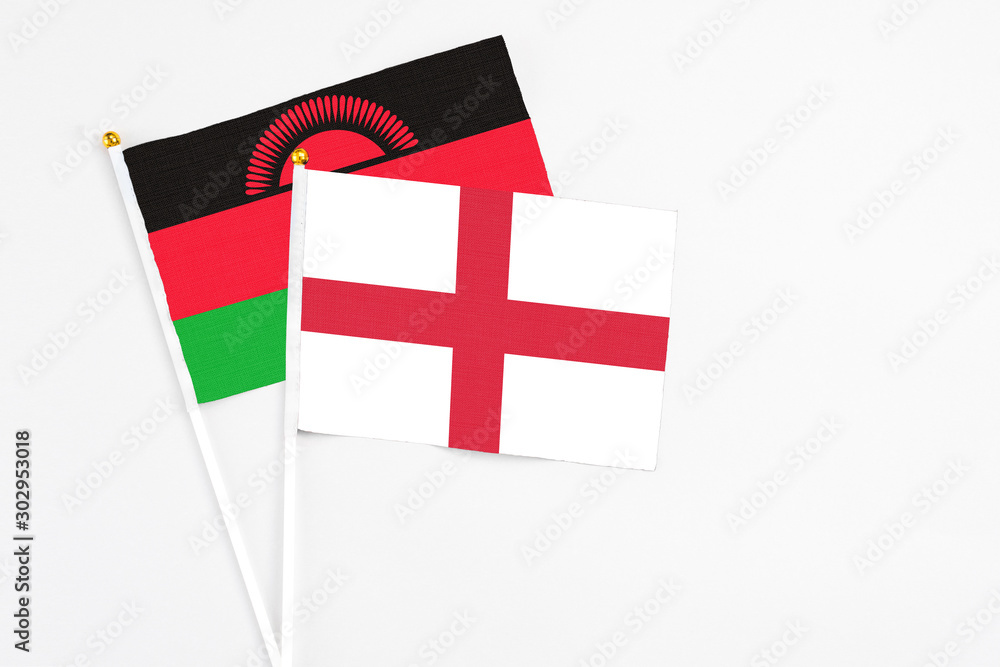 England and Malawi stick flags on white background. High quality fabric, miniature national flag. Peaceful global concept.White floor for copy space.