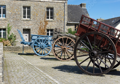 picturesque French village of Locronan with old horse-drawn carriages in the foreground