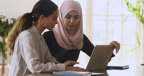 Female muslim manager mentor consulting client teaching intern with laptop photo