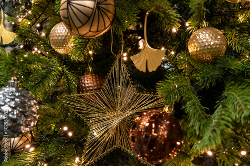 Gold and bronze Christmas tree decorations. Golden star on a vintage New Year tree.