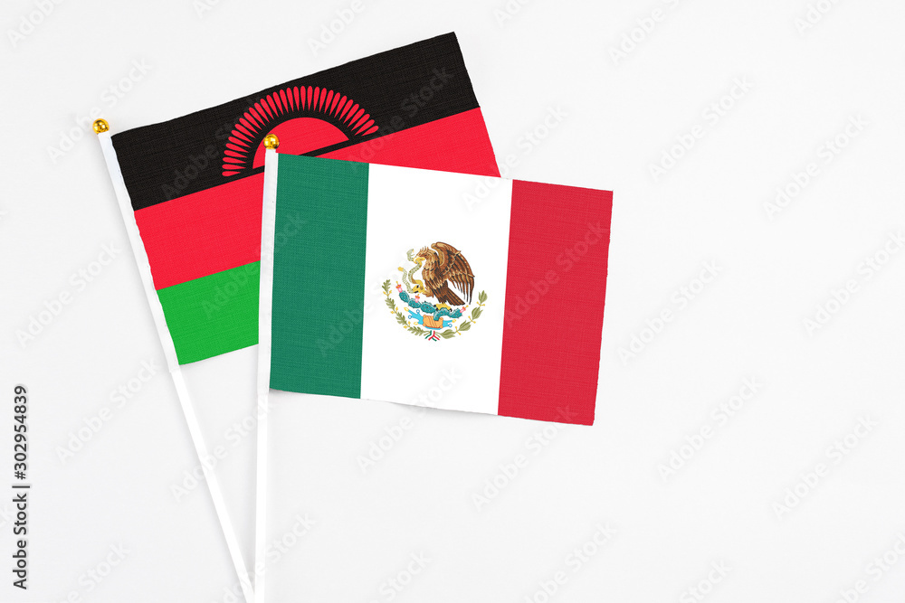 Mexico and Malawi stick flags on white background. High quality fabric, miniature national flag. Peaceful global concept.White floor for copy space.