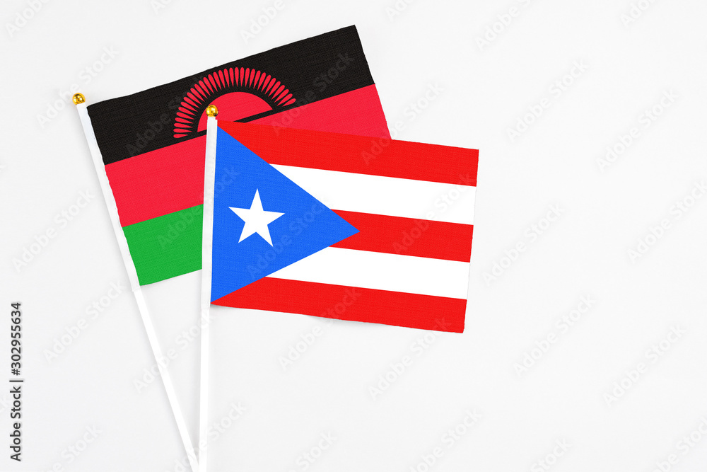 Puerto Rico and Malawi stick flags on white background. High quality fabric, miniature national flag. Peaceful global concept.White floor for copy space. Puerto Rico and Malawi stick flags on white background. High quality fabric, miniature national flag. Peaceful global concept.White floor for copy space.