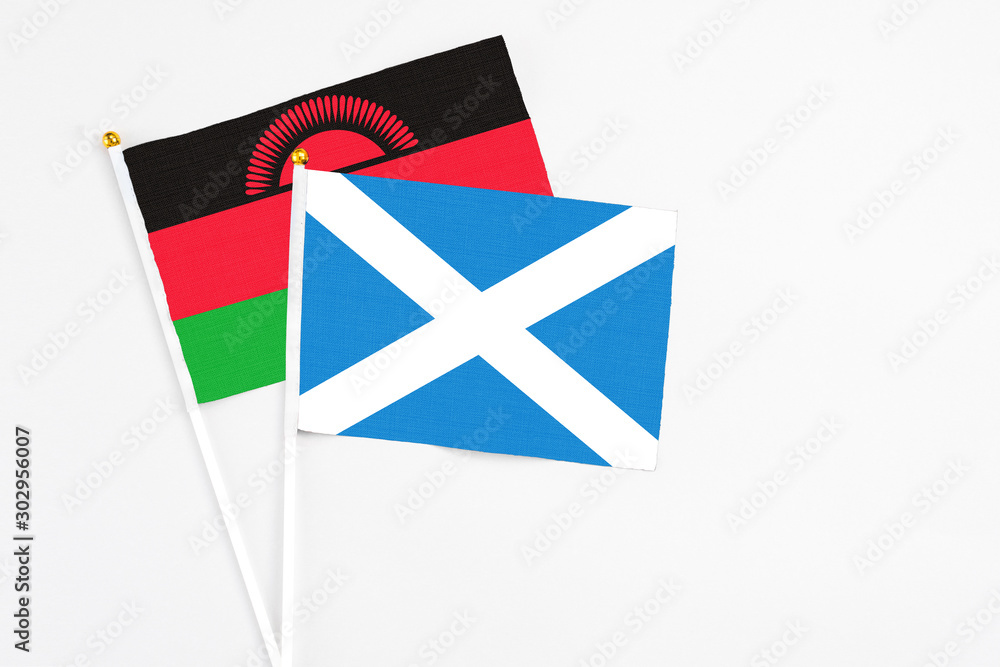 Scotland and Malawi stick flags on white background. High quality fabric, miniature national flag. Peaceful global concept.White floor for copy space. Scotland and Malawi stick flags on white background. High quality fabric, miniature national flag. Peaceful global concept.White floor for copy space.