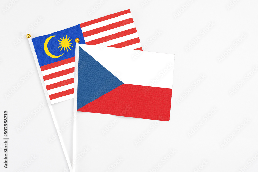 Obraz premium Czech Republic and Malaysia stick flags on white background. High quality fabric, miniature national flag. Peaceful global concept.White floor for copy space.