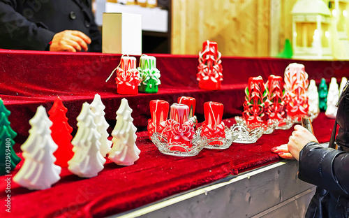 Festive colorful wax candles of Christmas Market in Vilnius, Lithuania in Europe in winter. Street Xmas and holiday fair at European city. Advent Decoration and Stalls with Crafts Items on Bazaar photo