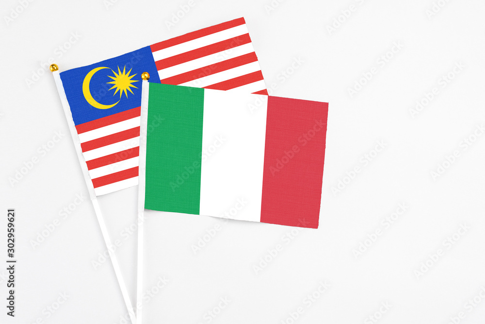 Italy and Malaysia stick flags on white background. High quality fabric, miniature national flag. Peaceful global concept.White floor for copy space. Italy and Malaysia stick flags on white background. High quality fabric, miniature national flag. Peaceful global concept.White floor for copy space.