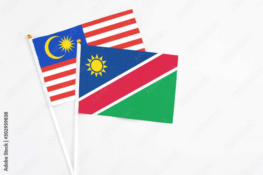 Namibia and Malaysia stick flags on white background. High quality fabric, miniature national flag. Peaceful global concept.White floor for copy space. Namibia and Malaysia stick flags on white background. High quality fabric, miniature national flag. Peaceful global concept.White floor for copy space.