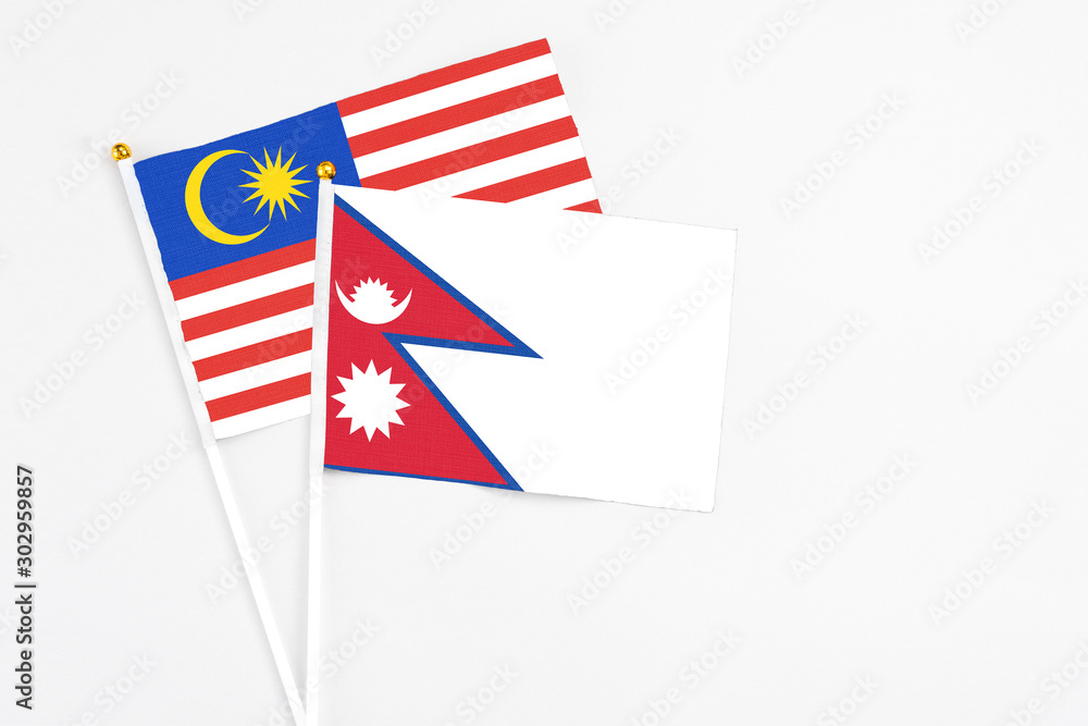 Nepal and Malaysia stick flags on white background. High quality fabric, miniature national flag. Peaceful global concept.White floor for copy space. Nepal and Malaysia stick flags on white background. High quality fabric, miniature national flag. Peaceful global concept.White floor for copy space.