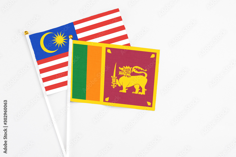 Sri Lanka and Malaysia stick flags on white background. High quality fabric, miniature national flag. Peaceful global concept.White floor for copy space. Sri Lanka and Malaysia stick flags on white background. High quality fabric, miniature national flag. Peaceful global concept.White floor for copy space.