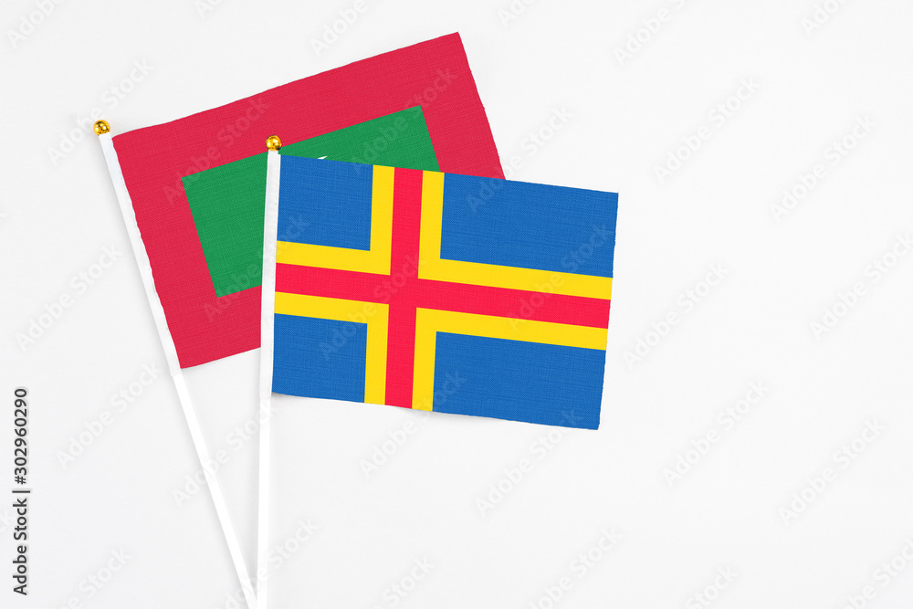 Aland Islands and Maldives stick flags on white background. High quality fabric, miniature national flag. Peaceful global concept.White floor for copy space.