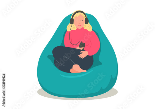 Woman relaxing  in bean bag and listening podcasts, online training, music, or online radio. Girl in earphones sitting in comfortable armchair. 