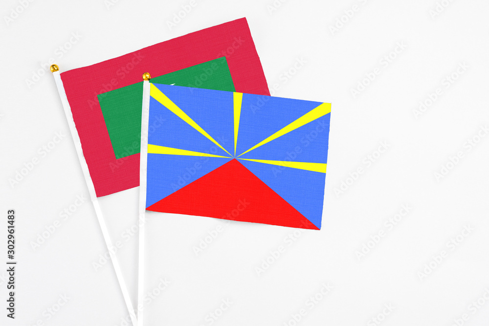 Reunion and Maldives stick flags on white background. High quality fabric, miniature national flag. Peaceful global concept.White floor for copy space.