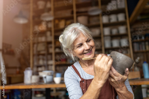 Fotografie Senior woman pottery artist makes ceramics from clay
