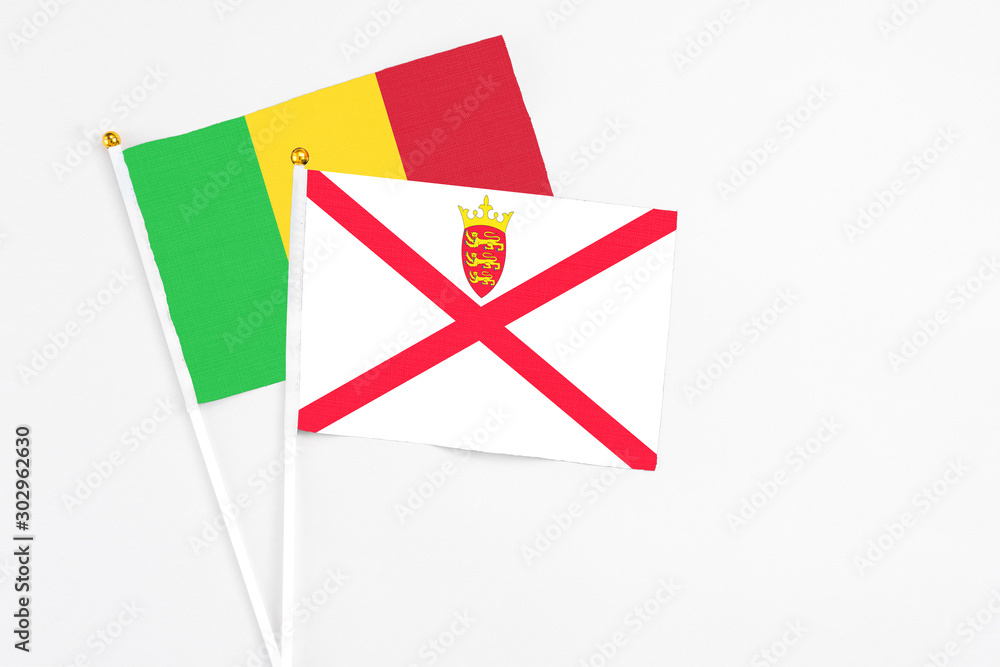 Jersey and Mali stick flags on white background. High quality fabric, miniature national flag. Peaceful global concept.White floor for copy space. Jersey and Mali stick flags on white background. High quality fabric, miniature national flag. Peaceful global concept.White floor for copy space.