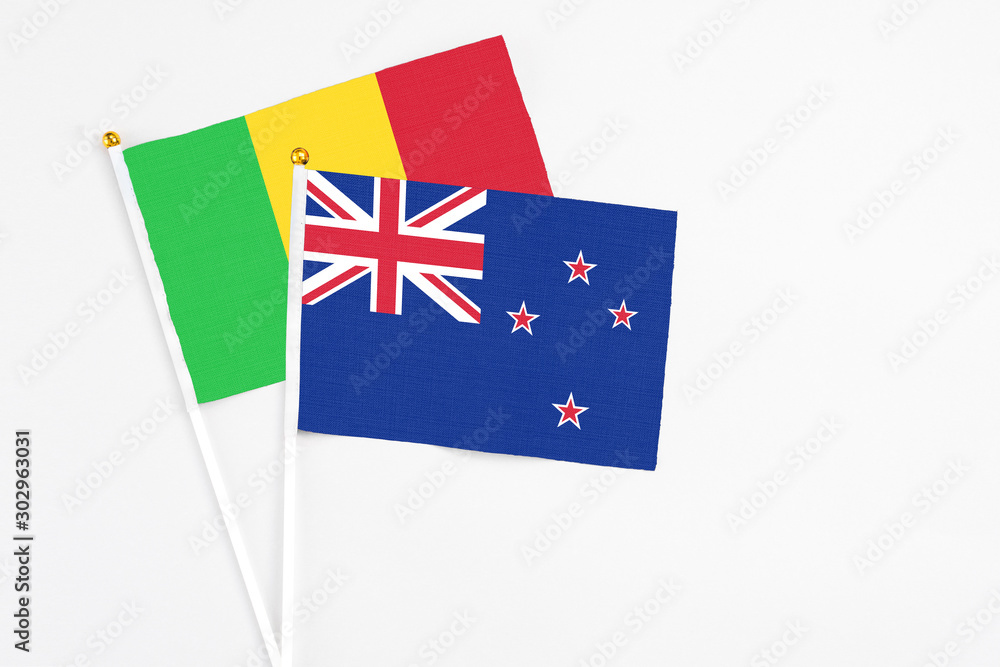 Fototapeta premium New Zealand and Mali stick flags on white background. High quality fabric, miniature national flag. Peaceful global concept.White floor for copy space.