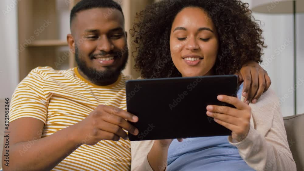 technology, internet and people concept - happy african american couple with tablet computer at home technology, internet and people concept - happy african american couple with tablet computer at home