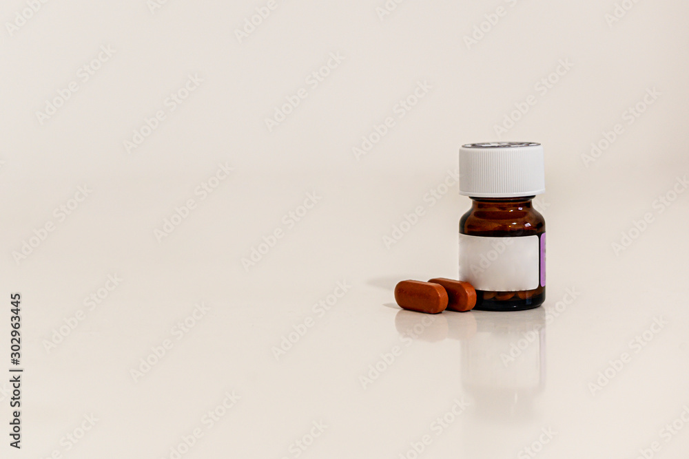 Brown jar with white cover with tablets within isolated on white background.