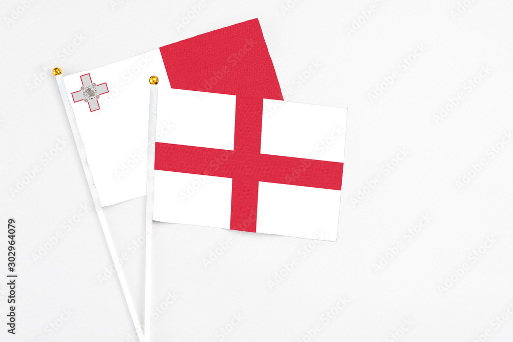England and Malta stick flags on white background. High quality fabric, miniature national flag. Peaceful global concept.White floor for copy space.
